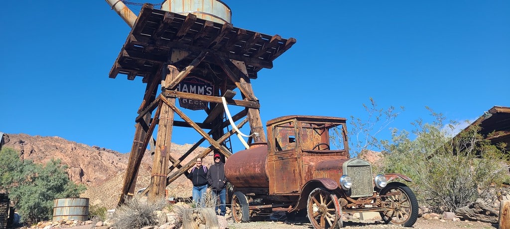 rusty truck and water tower seen in the Techatticup Gold Mine Old West mining town.